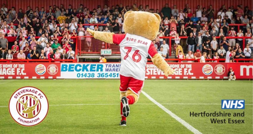 Stevenage FC mascot and logos of Stevenage FC Foundation and the NHS