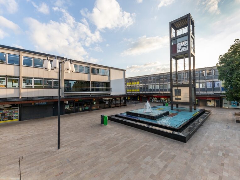 A mid-20th century shopping development with cubic clock tower