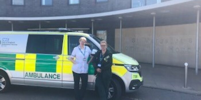 The west Essex falls car (ambulance) parked in front of St Margaret's Hospital in Epping. There are two health care professionals stood in front of the car