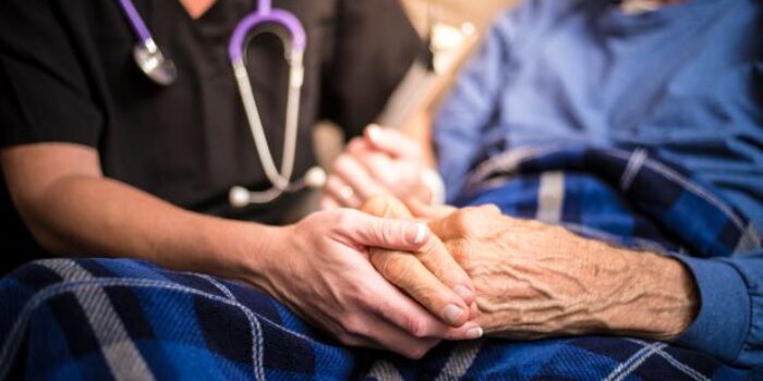 Older man being comforted by carer