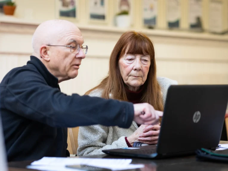 Older man and woman looking at laptop